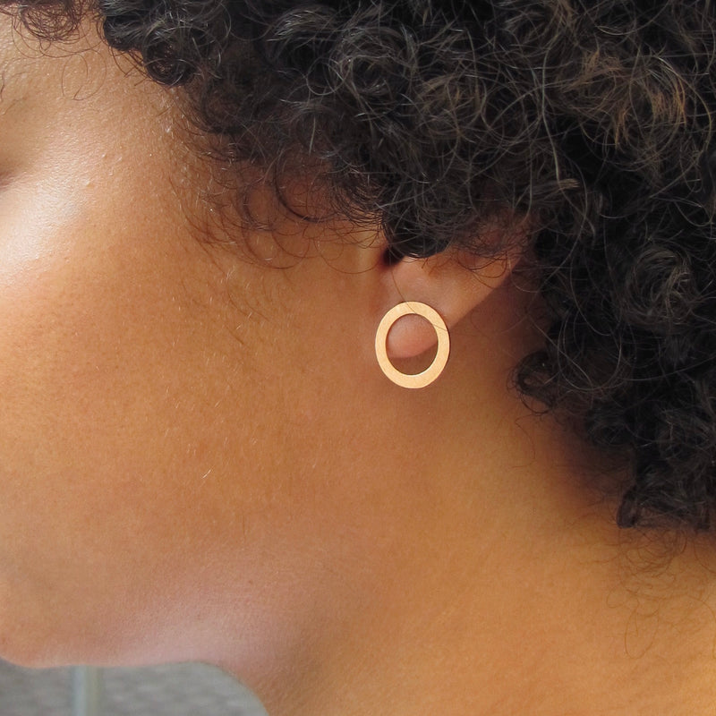 Woman wearing gold plated circle earrings